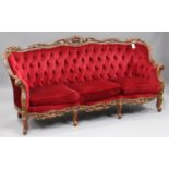 A late 20th century carved showframe three-piece suite, upholstered in claret velour, comprising a