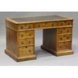 A late Victorian Gothic Revival oak twin pedestal desk, fitted with an arrangement of nine drawers