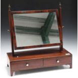 A late George III rosewood swing frame mirror, the base fitted with two drawers, on bracket feet,