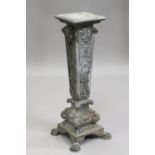 A late 19th/early 20th century cast metal pedestal, the tapering column cast with masks and scrolls,