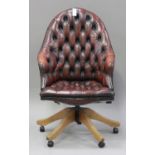 A 20th century reproduction red buttoned leather revolving office chair, raised on outswept legs and