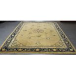 A Chinese carpet, late 19th/early 20th century, the pale yellow field sparsely decorated with a