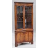 A late 20th century mahogany concave floor-standing corner cabinet, fitted with two astragal