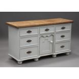 A Victorian style pine and white painted dresser base, fitted with seven drawers and a cupboard,