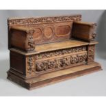 A 19th century Continental oak hall bench profusely carved with masks and floral scrolls, the