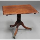 A Regency mahogany tip-top supper table, the moulded rectangular top above a turned stem and