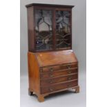 A George III mahogany bureau bookcase, the dentil moulded pediment above a pair of astragal glazed