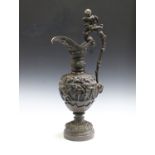 A late 19th century brown patinated cast bronze ornamental ewer, the scrolling handle surmounted