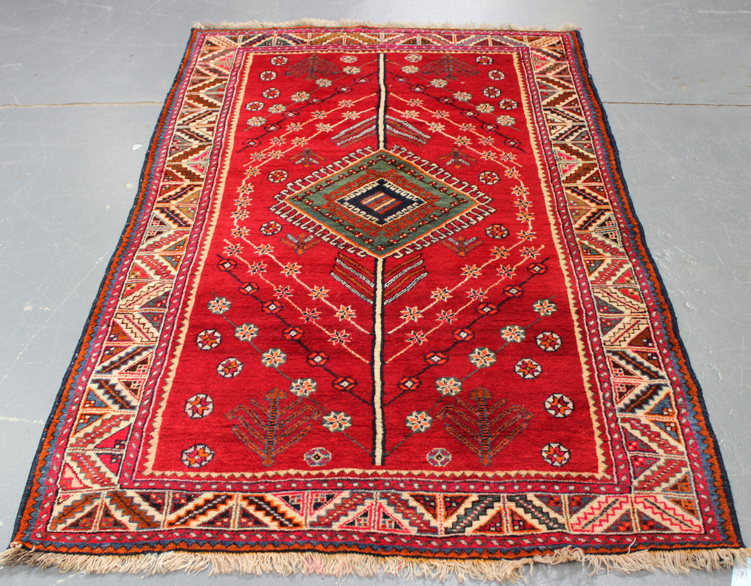 A Shiraz rug, South-west Persia, late 20th century, the red field with a green lozenge medallion,