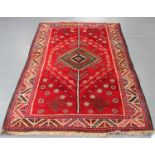 A Shiraz rug, South-west Persia, late 20th century, the red field with a green lozenge medallion,