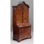 A George I and later burr walnut bureau bookcase, the arch moulded pediment above two arched panel