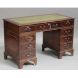 A late 20th century mahogany twin-pedestal desk, the green leather top above an arrangement of