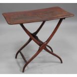 A mid-19th century mahogany coaching table, the curved rectangular top above a folding base,