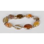A gold and agate bracelet, claw set with nine oval slightly graduated vari-coloured agates, on a