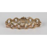 A 9ct two-colour gold bracelet in a faceted oval and textured bar link design, on a snap clasp