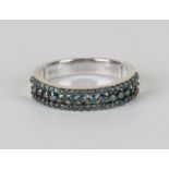 A 9ct white gold and treated blue diamond half-hoop eternity ring, mounted with a row of principal