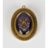 A gold and mauve paste oval pendant brooch, the mauve paste enamelled with a spray of flowers, the