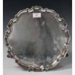 A George V silver salver with piecrust border and volute scroll feet, Chester 1931 by S. Blanckensee