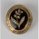 A Victorian gold, seed pearl set and black enamelled oval mourning brooch, the front mounted with