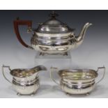 A George VI silver three-piece tea set of cushion form with gadrooned rim and bun feet, comprising