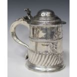 A George I silver tankard with domed hinged lid and scroll thumbpiece, the cylindrical body with