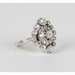 A diamond cluster ring, claw set with the principal circular cut diamond within a surround of