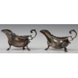 A pair of George V silver sauce boats, each with a foliate capped flying scroll handle, on scallop