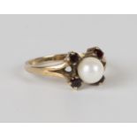 A 9ct gold, cultured pearl and garnet ring, mounted with four circular cut garnets, centred with a