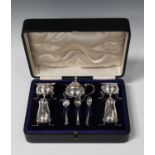 An Edwardian silver five-piece condiment set, comprising mustard, pair of salts and pair of peppers,