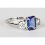 A white gold, tanzanite and diamond ring, mounted with an emerald cut tanzanite between circular cut