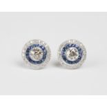 A pair of 18ct white gold, diamond and sapphire earrings, each collet set with a principal