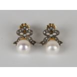 A pair of cultured pearl and diamond pendant earrings, each cultured pearl drop with a diamond set