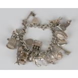 A silver faceted curblink charm bracelet, fitted with a variety of mostly silver charms, including a