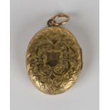 A Victorian gold oval pendant locket, glazed with portrait photographs within, the exterior with