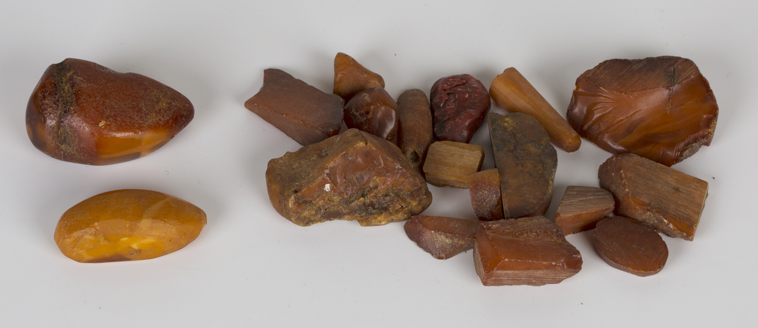 Eighteen pieces of mostly rough amber, including two pieces of butterscotch coloured amber.Buyer’s