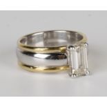 An 18ct two colour gold and diamond ring, claw set with an emerald cut diamond, London 2004, ring