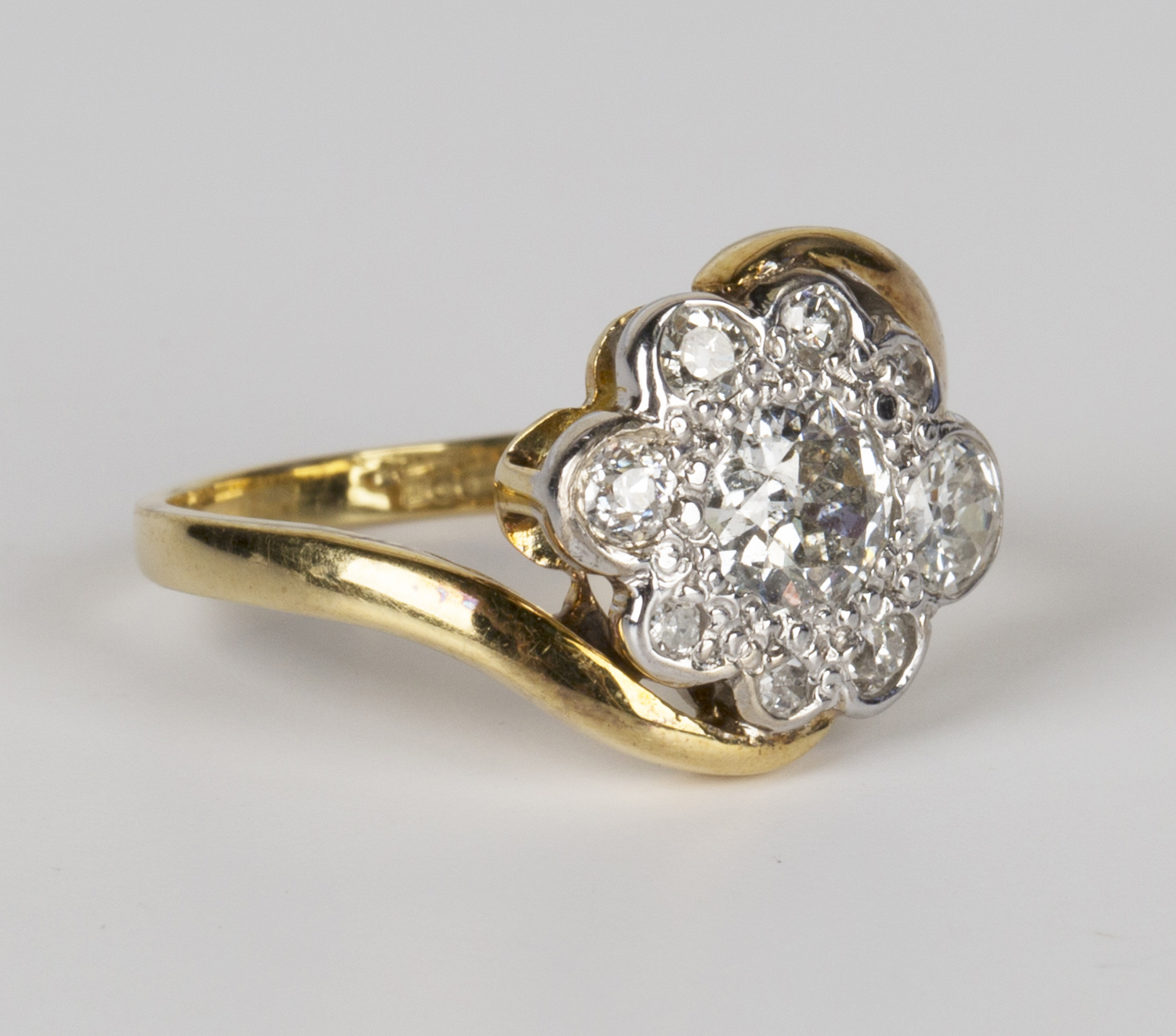 An 18ct gold and diamond cluster ring, mounted with the principal cushion shaped diamond within a