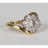 An 18ct gold and diamond cluster ring, mounted with the principal cushion shaped diamond within a