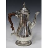 A George III silver coffee pot, the domed hinged lid and spiral reeded knop finial above a low