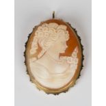 A gold mounted oval shell cameo pendant brooch, carved as a portrait of a lady with flowers,