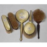 A George V silver and yellow enamel five-piece dressing table set, comprising hand mirror, pair of