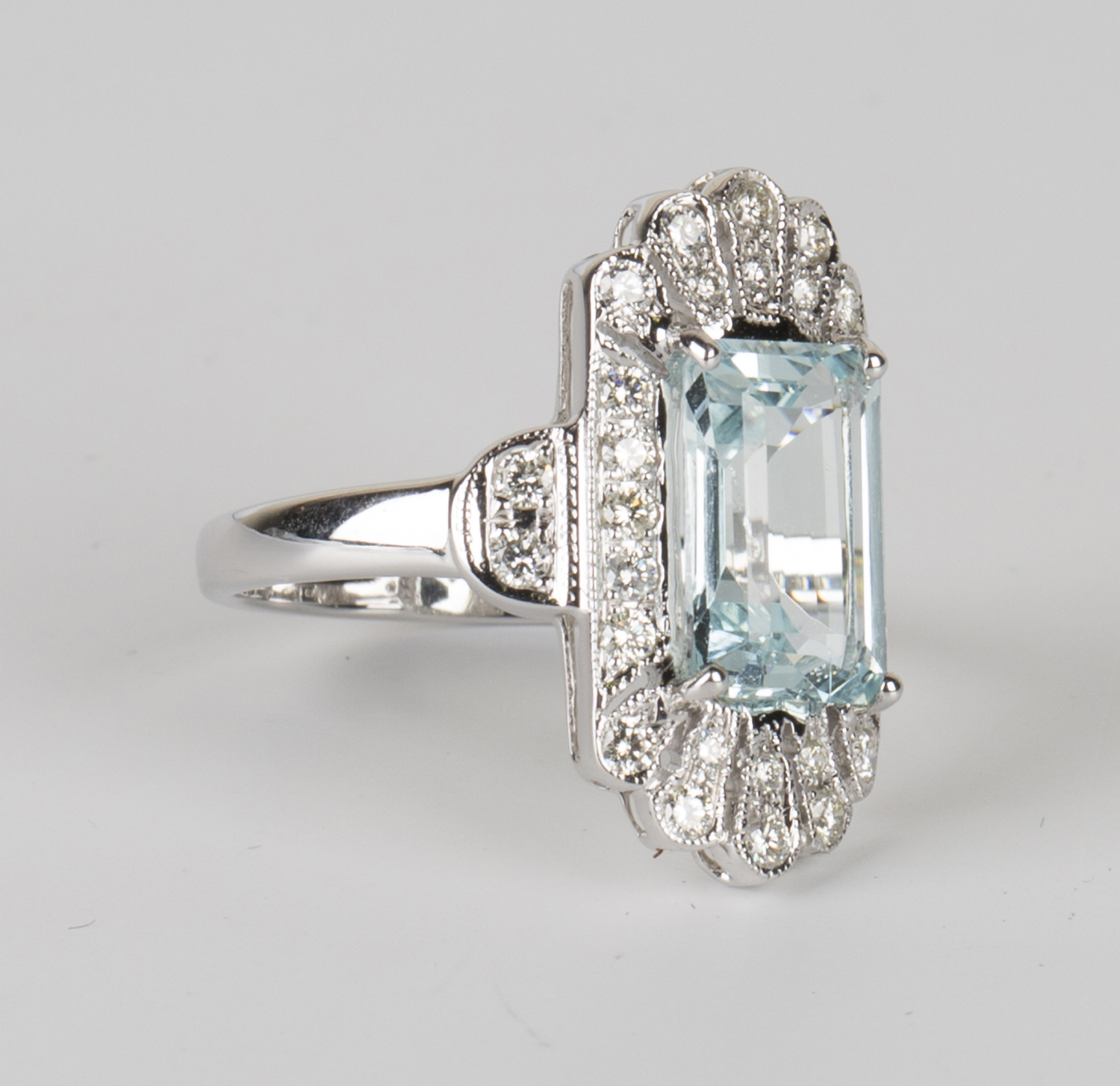 An 18ct white gold, aquamarine and diamond ring, claw set with a rectangular cut aquamarine within a