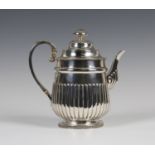 A George III silver coffee pot of half-reeded form with foliate capped scroll handle, on a