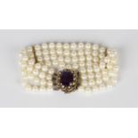 A four row bracelet of uniform cultured pearls on a gold, amethyst and seed pearl set shaped oval