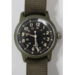 A Westclox US Army military issue green cased wristwatch, the black dial with luminous Arabic