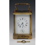 An early 20th century French brass cased carriage alarm clock with eight day movement striking on