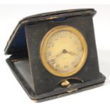 An Art Deco gilt metal cased keyless wind travelling bedside watch, the jewelled movement