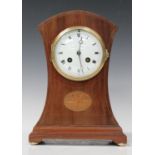 An Edwardian mahogany mantel clock with eight day movement striking on a gong, the circular enamel