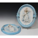 A large pair of French bisque porcelain oval wall plaques, circa 1900, each moulded in high relief