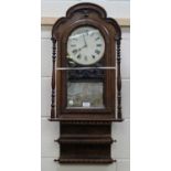 A late 19th century American walnut cased wall clock, the movement striking on a gong, the case with